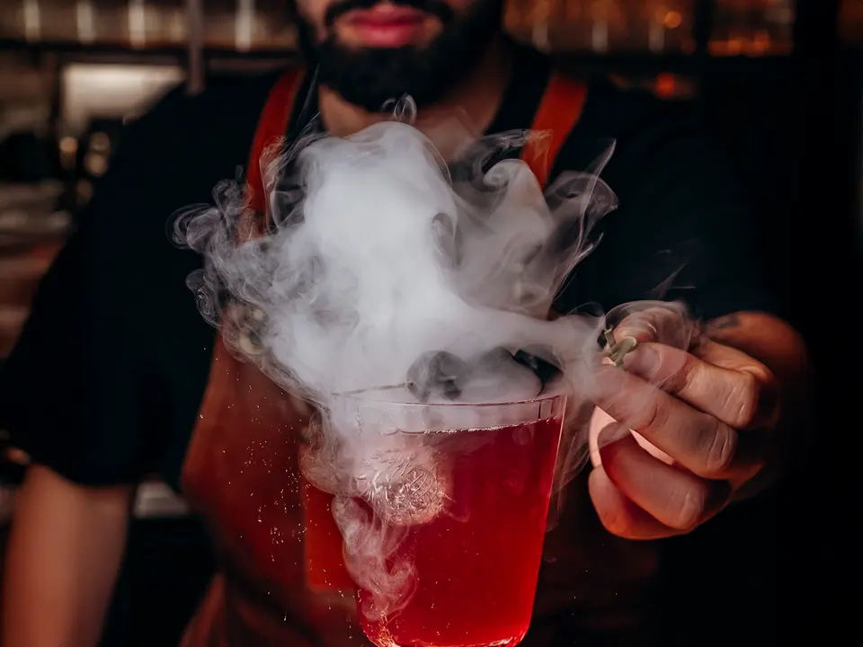 Um cocktail vermelho a fumegar ao balcão